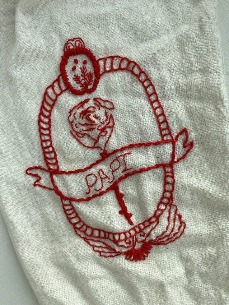 Hand embroided Papi Textile Tattoo on red thread.jpg