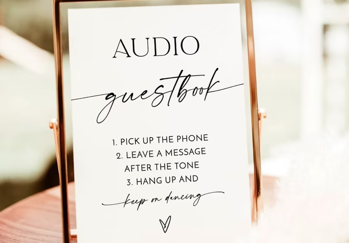 Sign with instructions for an audio guestbook, including tips to pick up the phone, leave a message after the tone, hang up, and keep on dancing, with a small heart at the bottom.