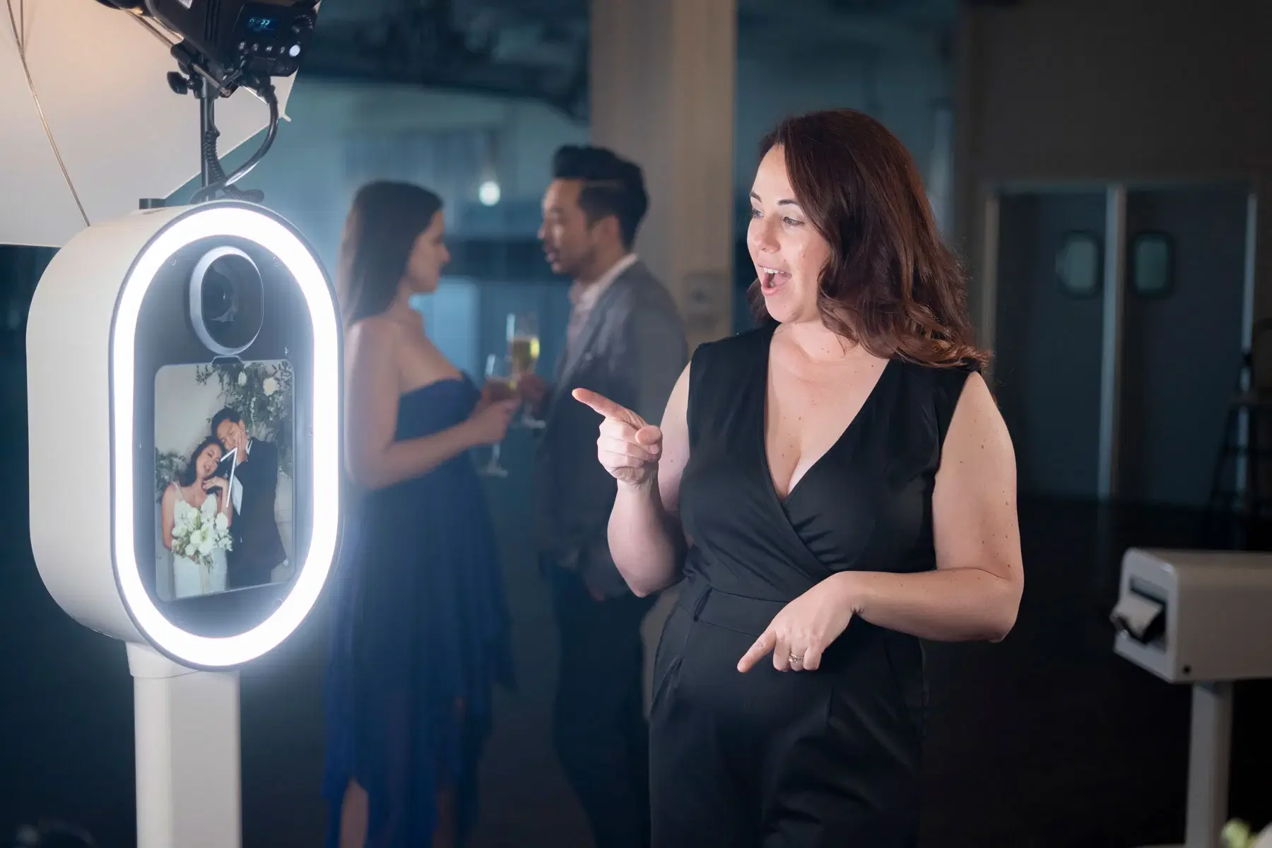 Black and white photo of a bride and groom close together, smiling with eyes closed, in front of a floral backdrop.