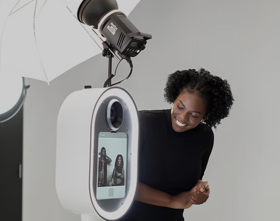 A woman smiling at a camera in a photo studio with professional lighting.