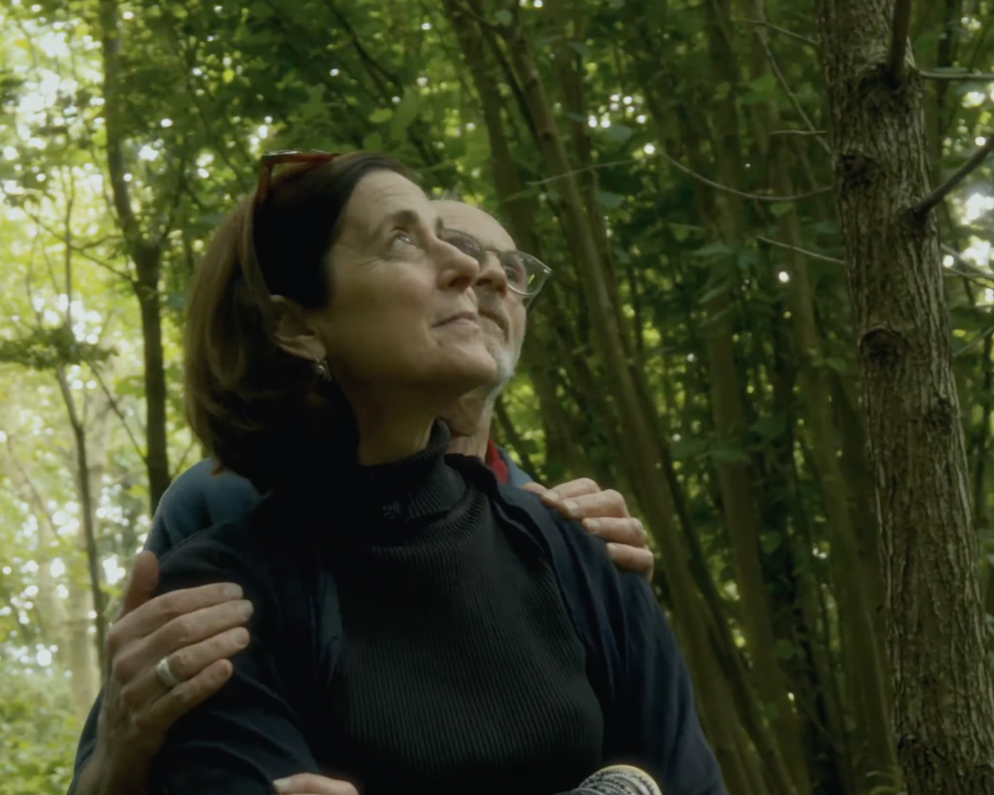 Deux personnes dans la forêt, une femme et un homme, en train de faire une pause et d'apprécier la nature.