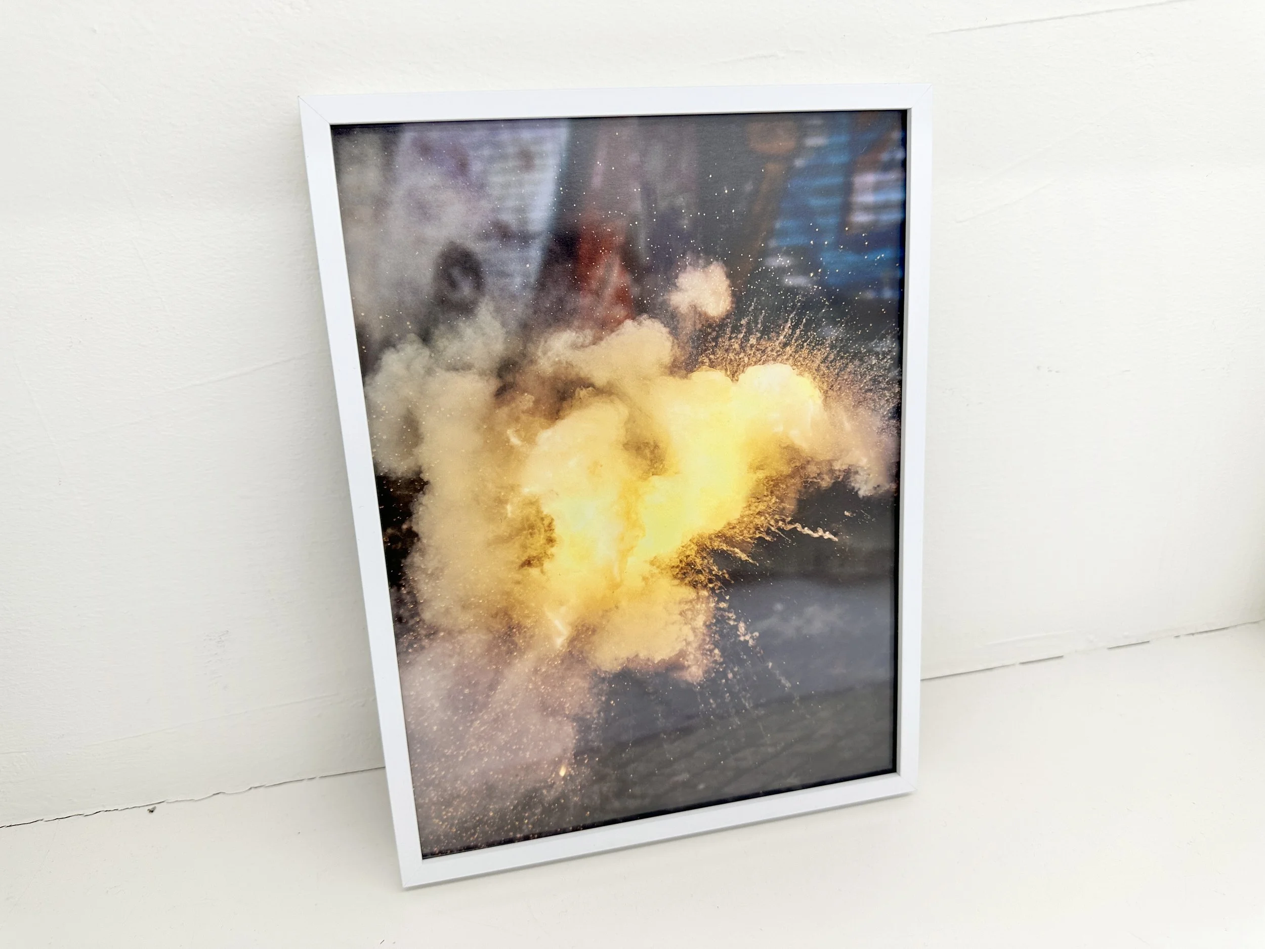 Artist captures the fleeting moment of fireworks, freezing the spark of lights in an instant. Without a specific context, the image evokes a sense of both war and celebration. This photography work is framed and displayed.
