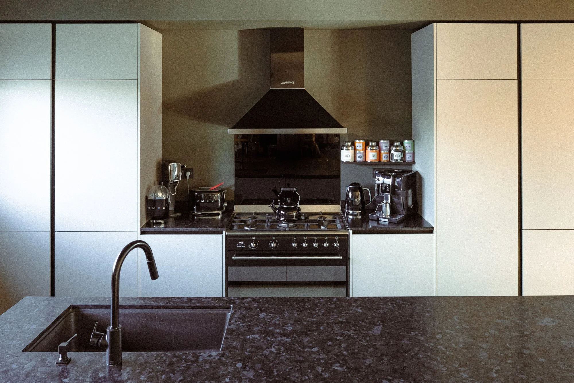 Cuisine mobalpa avec des façade en fenix un piano smeg ilot en pierre noir du Zimbabwe