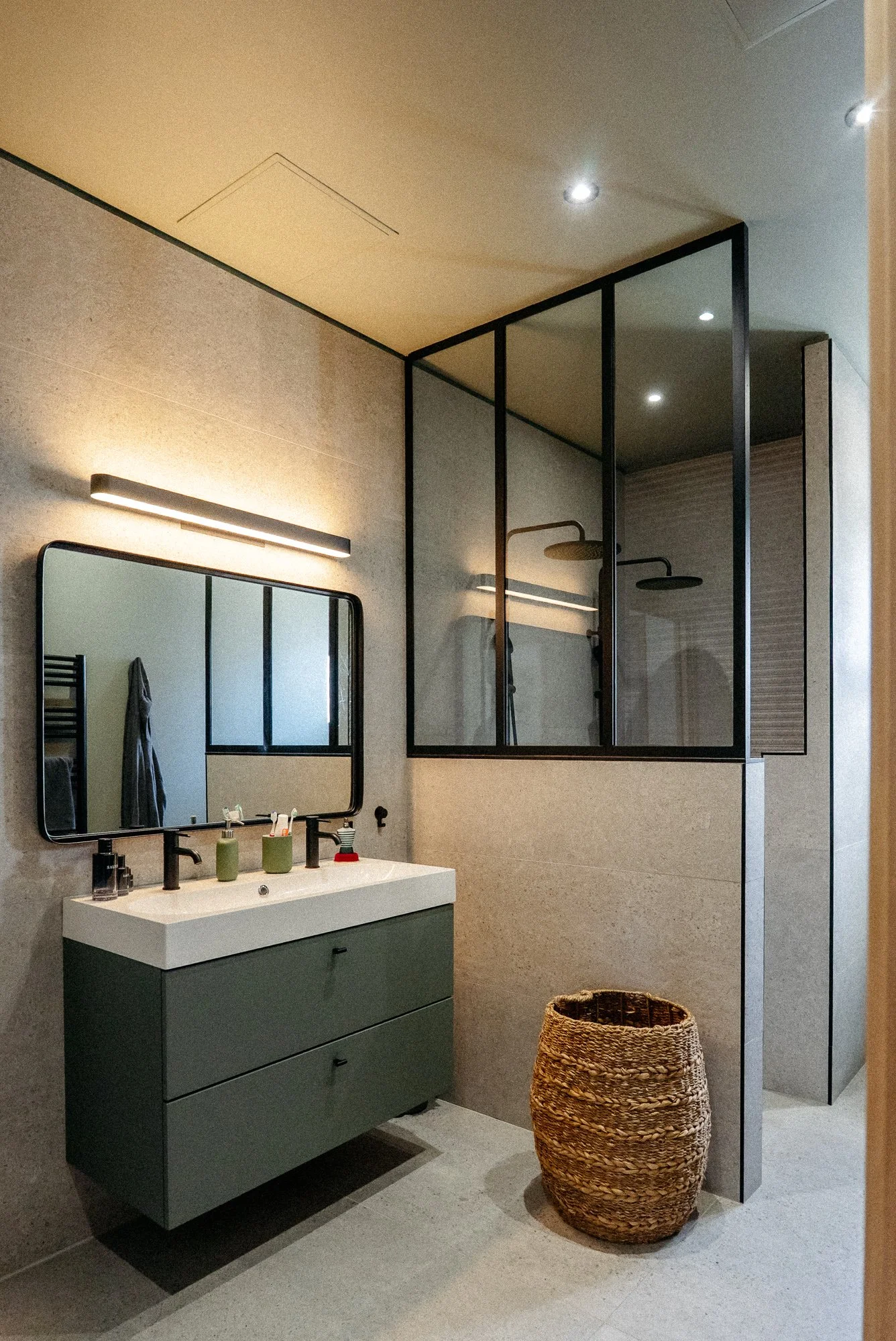 Salle de bain avec de grand carreaux XXL effet pierre de chez porcelanosa avec un meuble de salle de bain ikea kaki