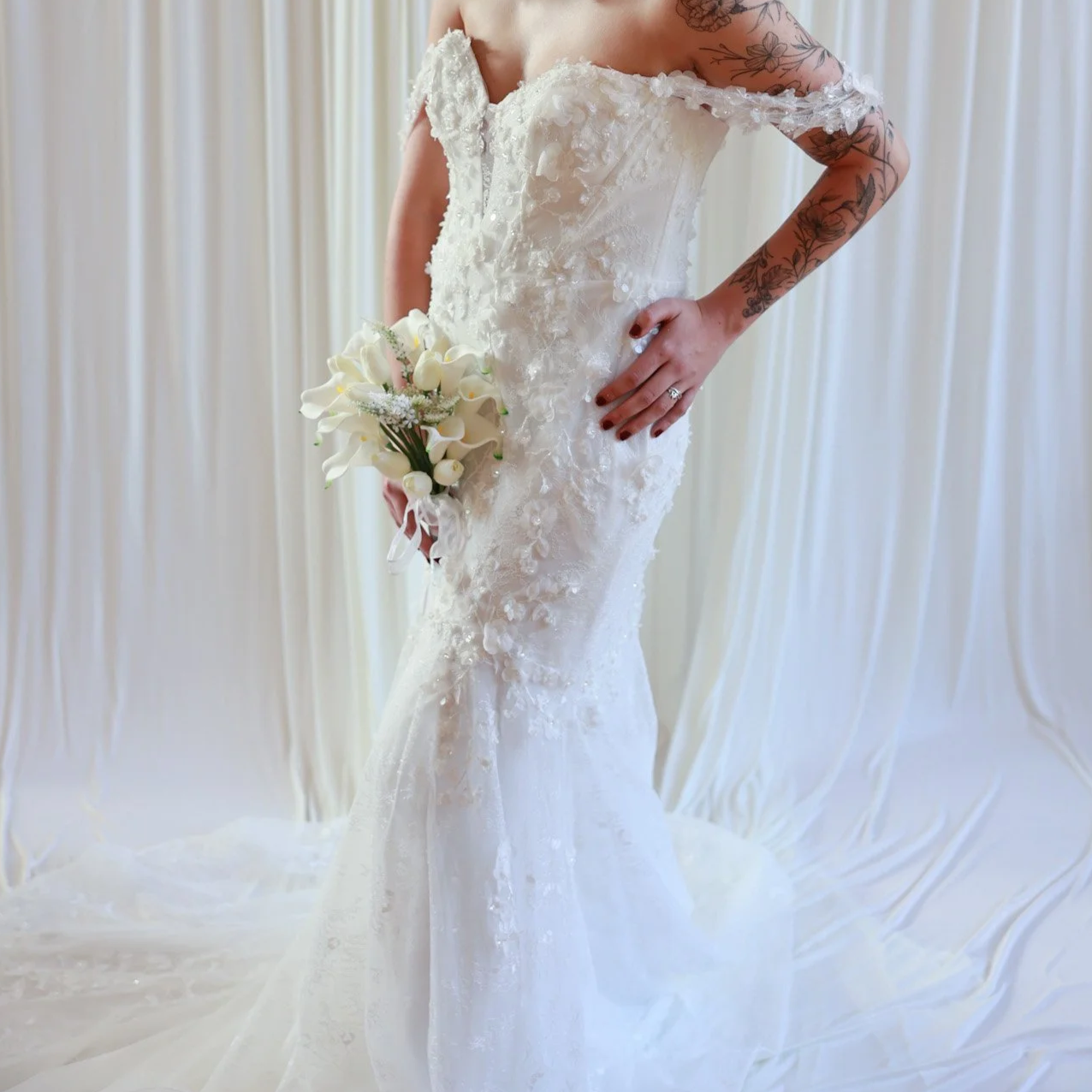 Off-the-shoulder lace wedding gown with floral appliqué detailing
