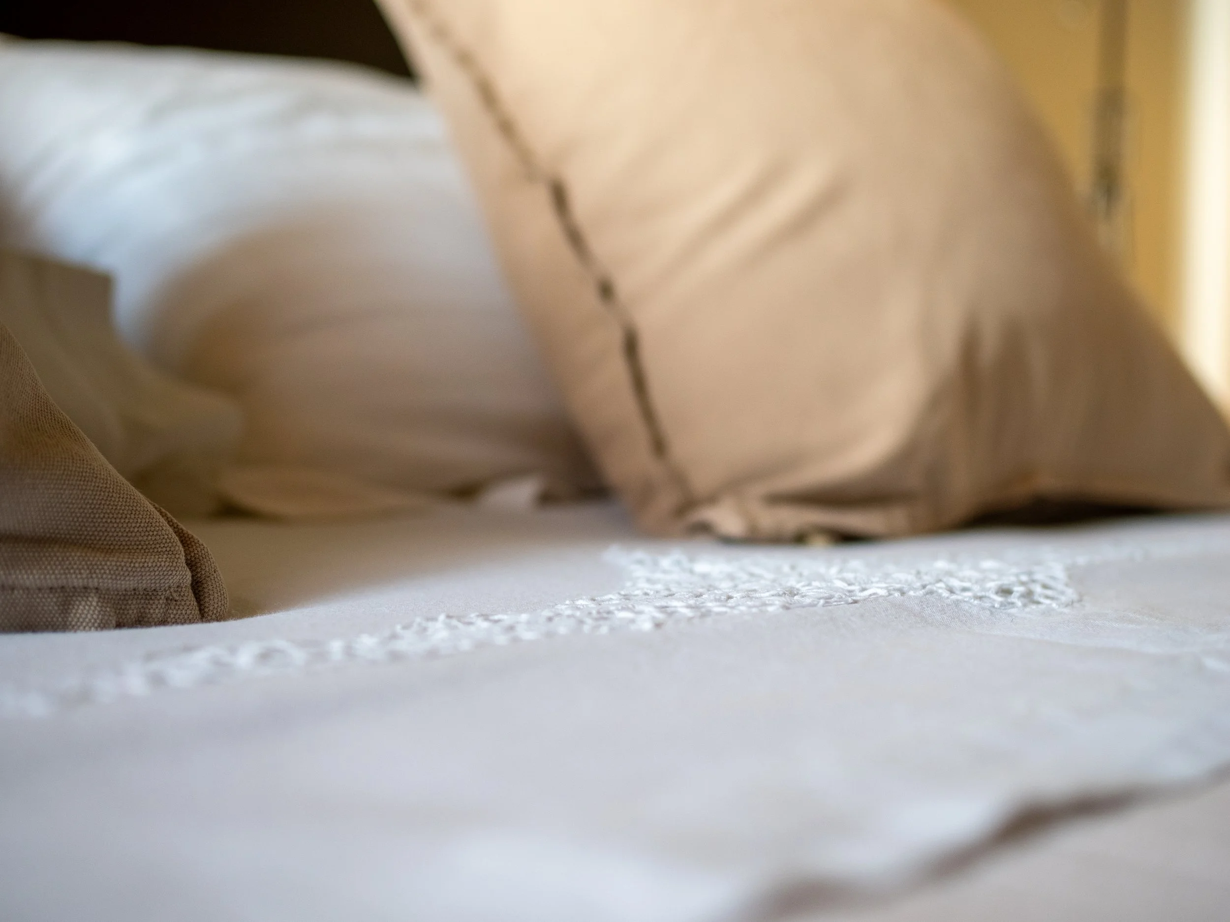 Dettaglio lenzuola del letto nella camera di Casa Roberta