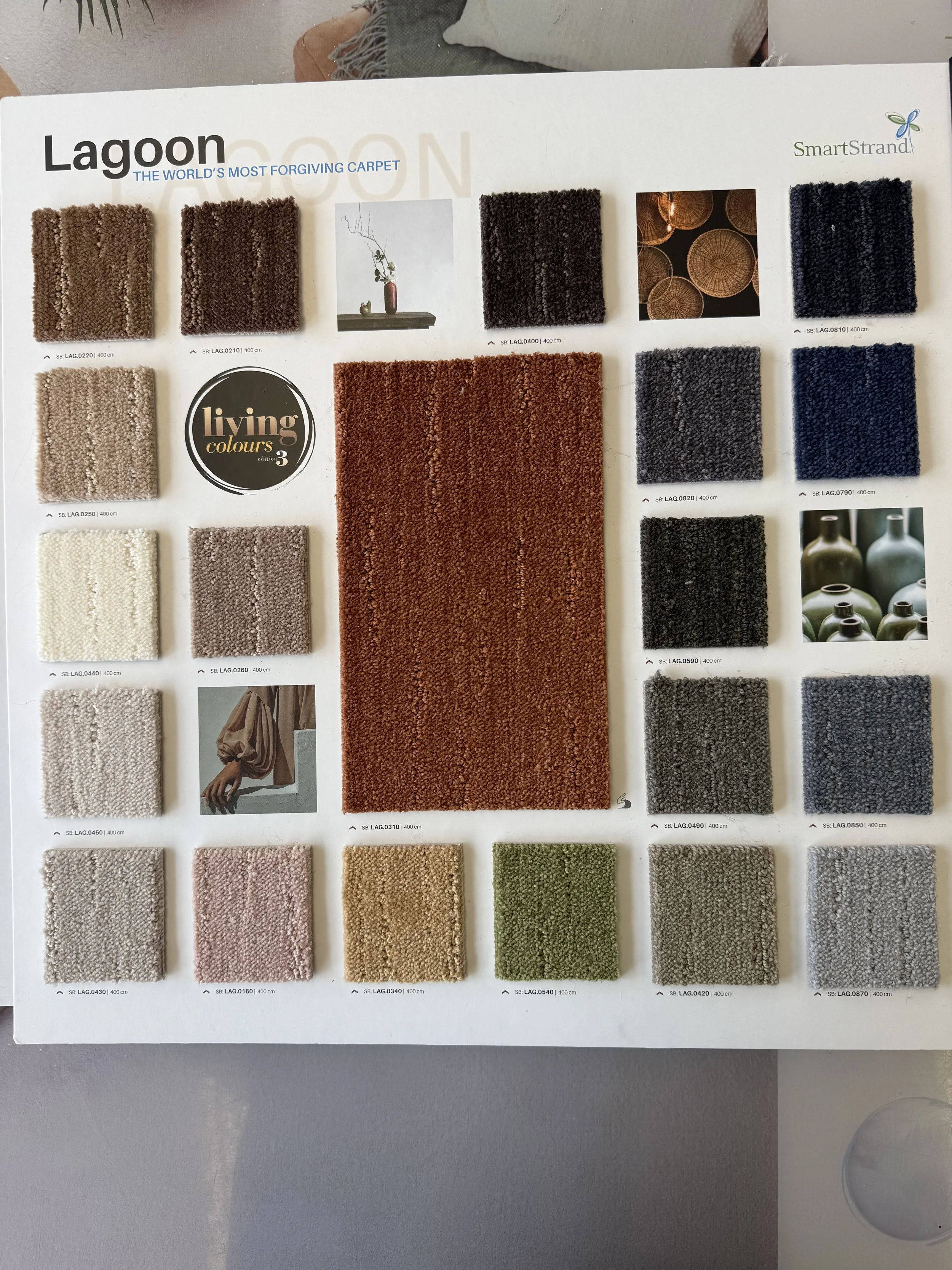 SmartStrand Carpet - A carpet sample display titled 'Lagoon' from SmartStrand, showing various colors and textures of carpet samples, primarily in earth tones, arranged in a grid on a white background.