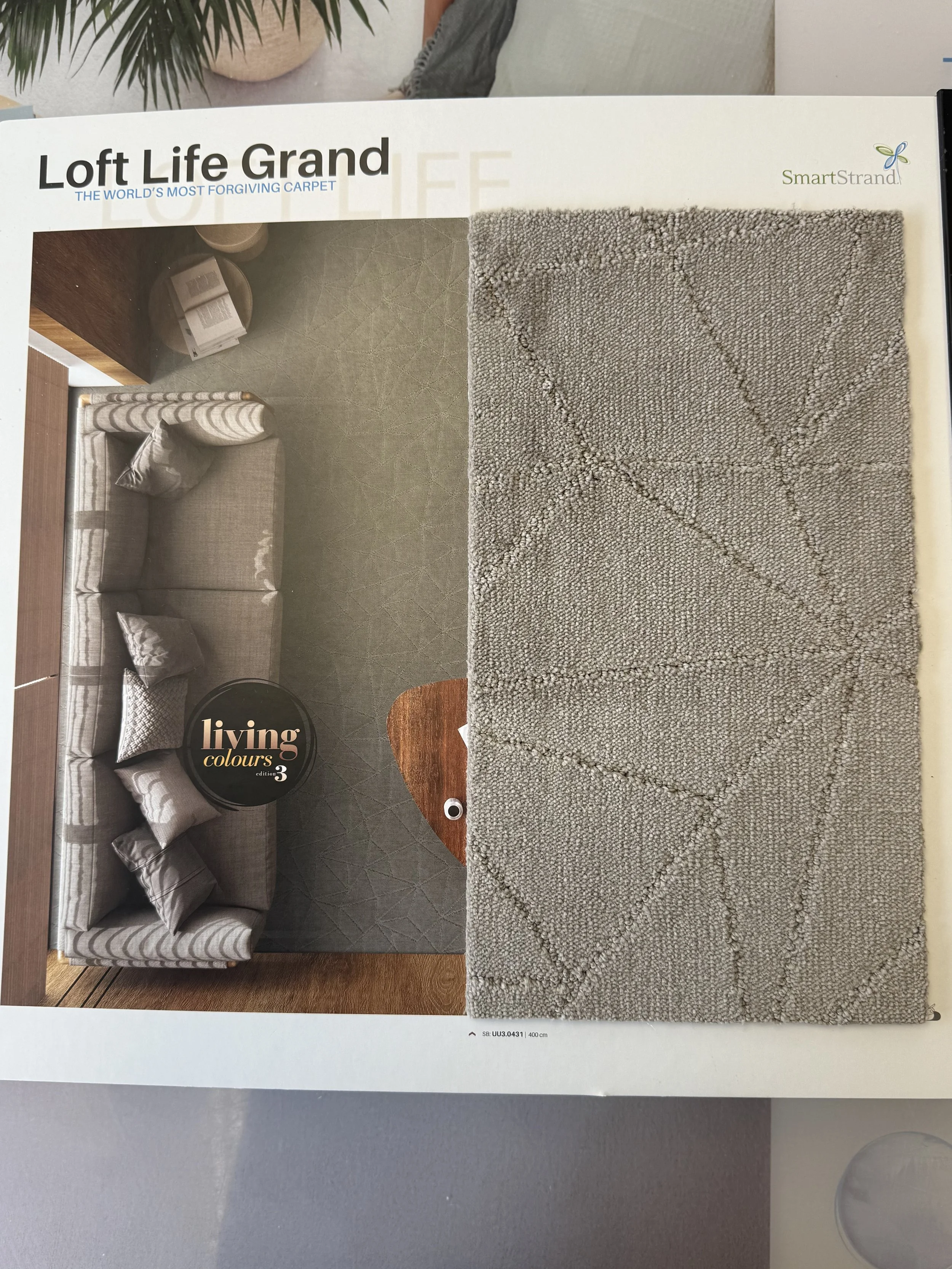 SmartStrand Carpet - A sample of beige textured area rug with a geometric pattern next to a living room scene on a magazine page.