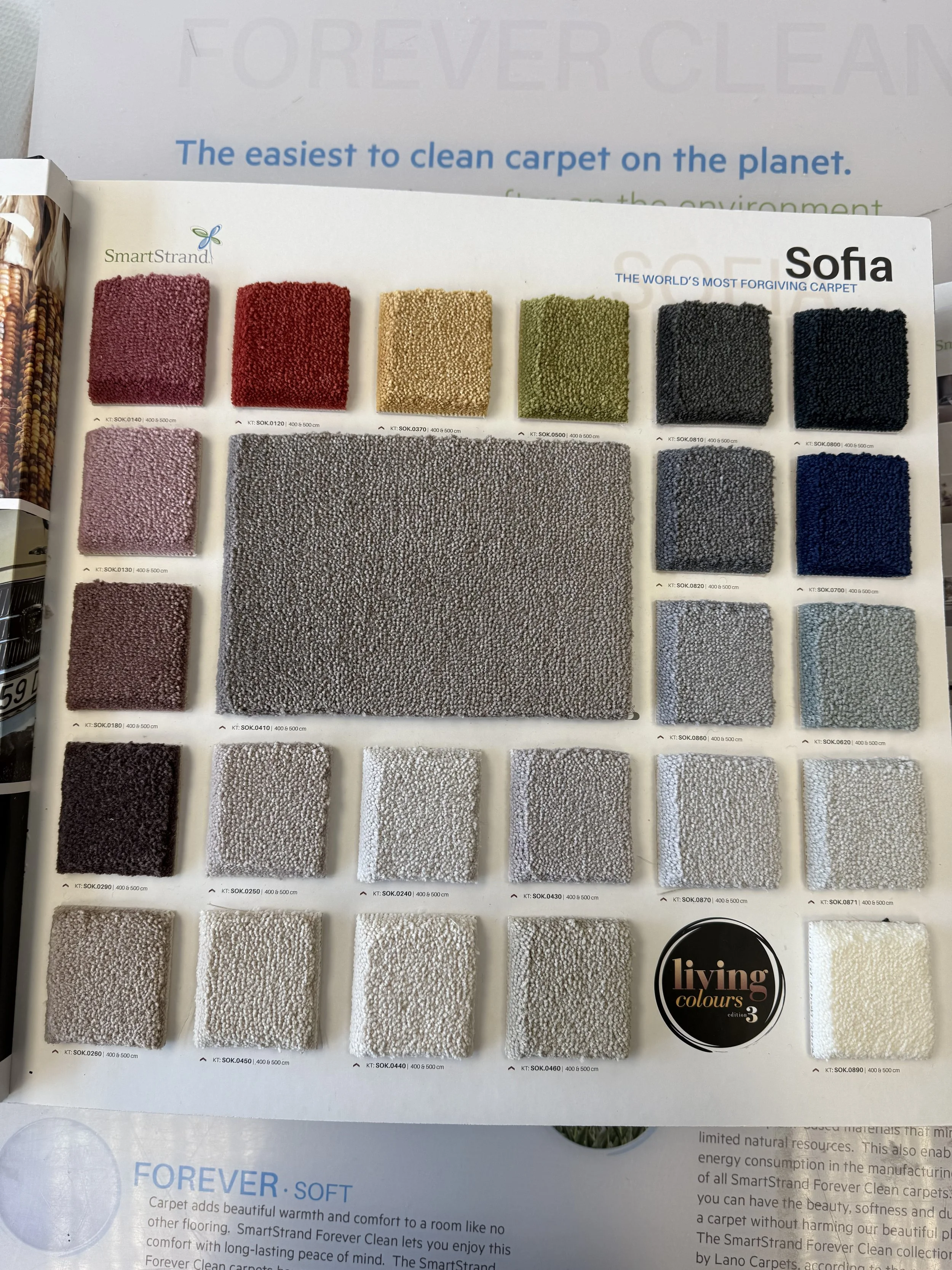 SmartStrand Carpet - Sample carpet color swatches in various shades, including pink, red, beige, black, gray, blue, and cream, displayed on a catalog page.