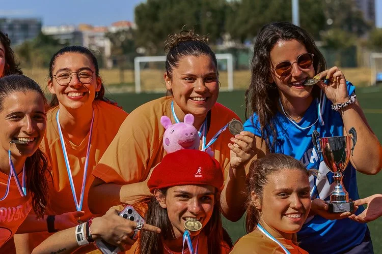 Women’s football team celebrating with medals and a trophy at the Portugal Summer Football Cup 2025.