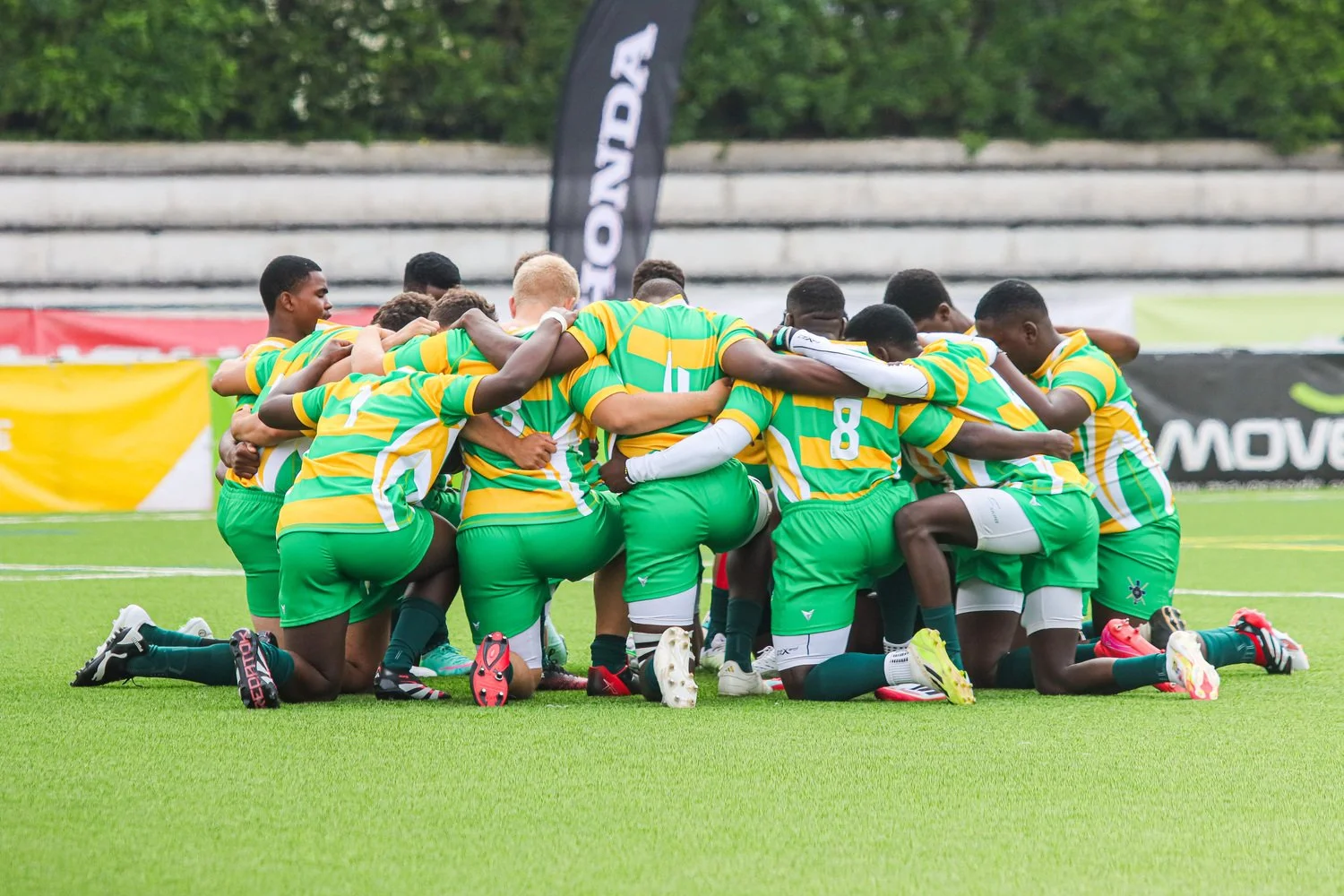 Youth rugby team in a pre-match huddle during the Portugal Rugby Youth Festival, showing unity, focus and team spirit on the pitch.
