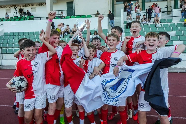 Youth football team celebrating their victory with the trophy at the Lisbon Football Youth Cup 2025.