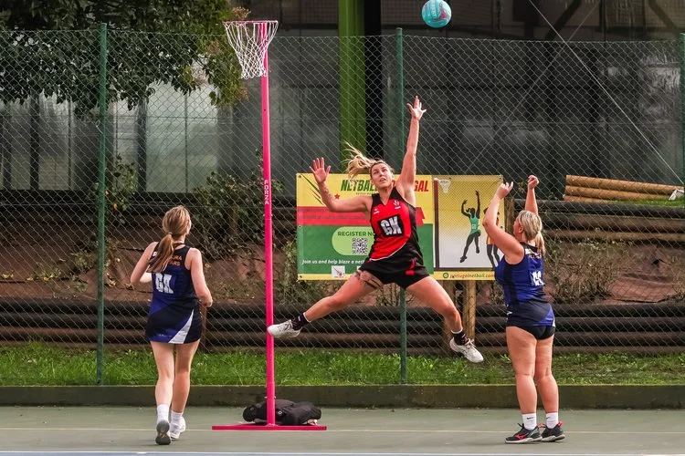 Women playing netball and one of them is jumping to catch the ball.jpg
