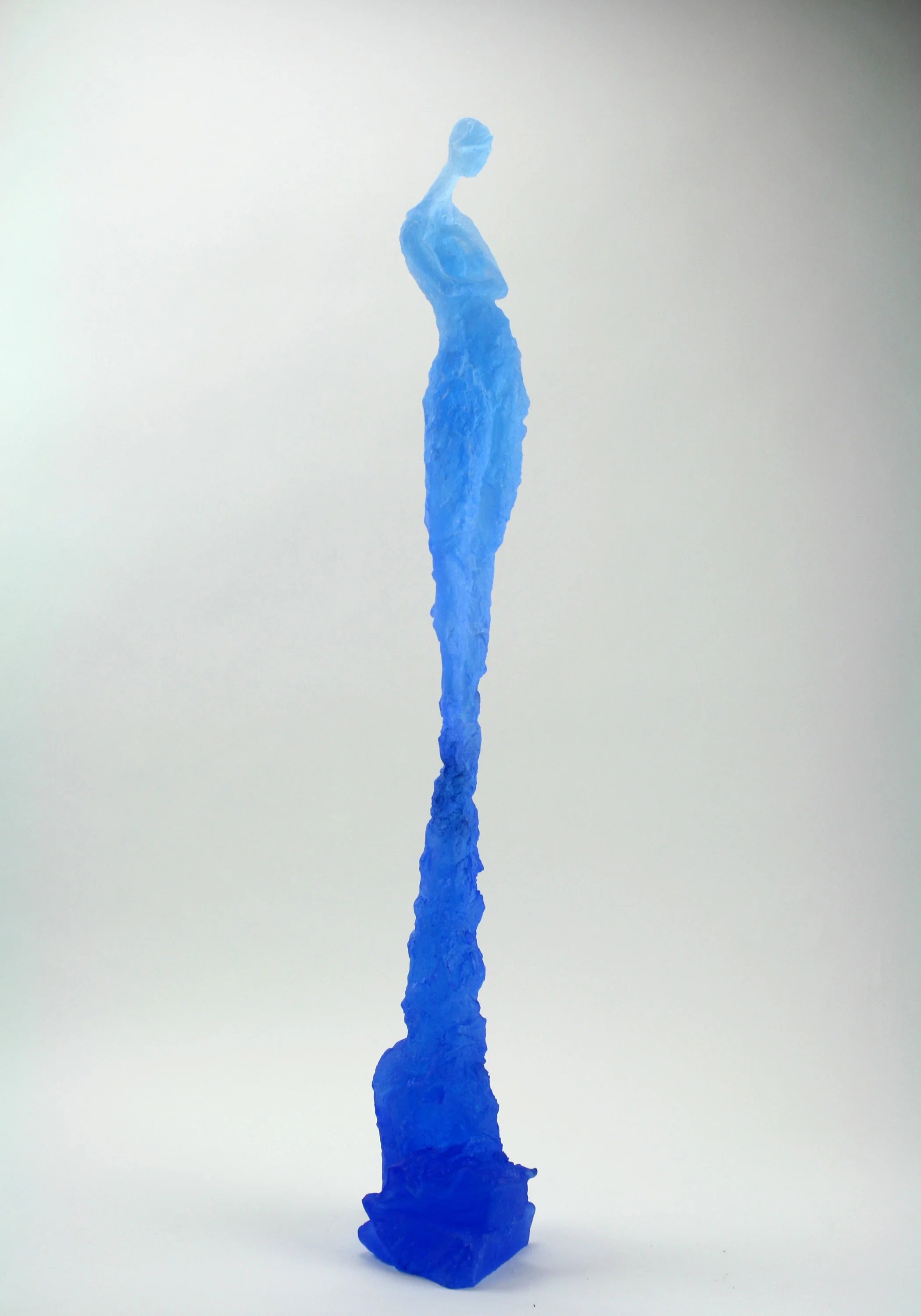 Blue abstract sculpture resembling a human figure with an elongated and textured form, standing upright on a white background.