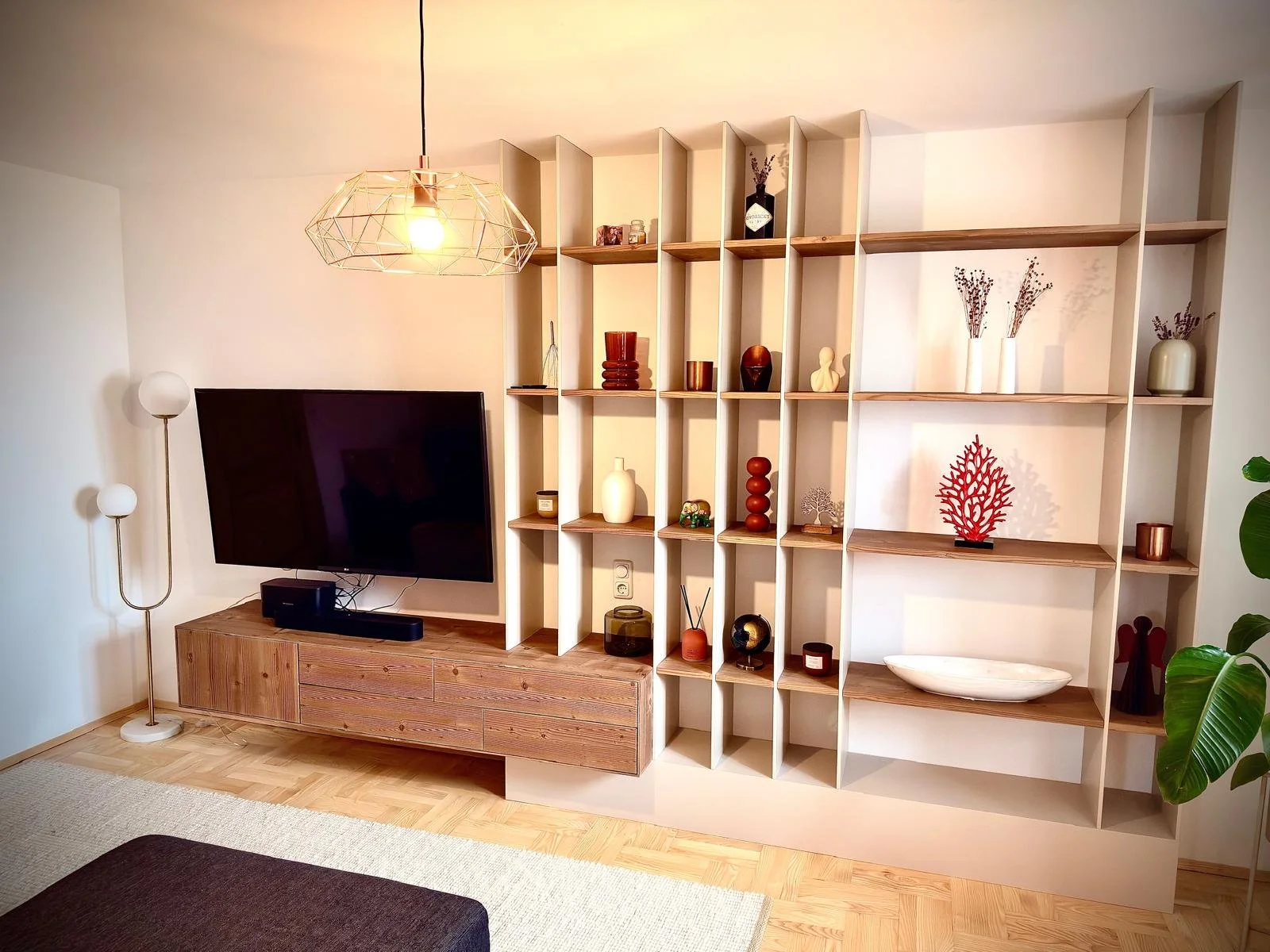 Moderner wohnzimmer mit TV, Holzmöbel und dekorativen Vasen und Skulpturen auf einer offenen, hohen Regaleinrichtung