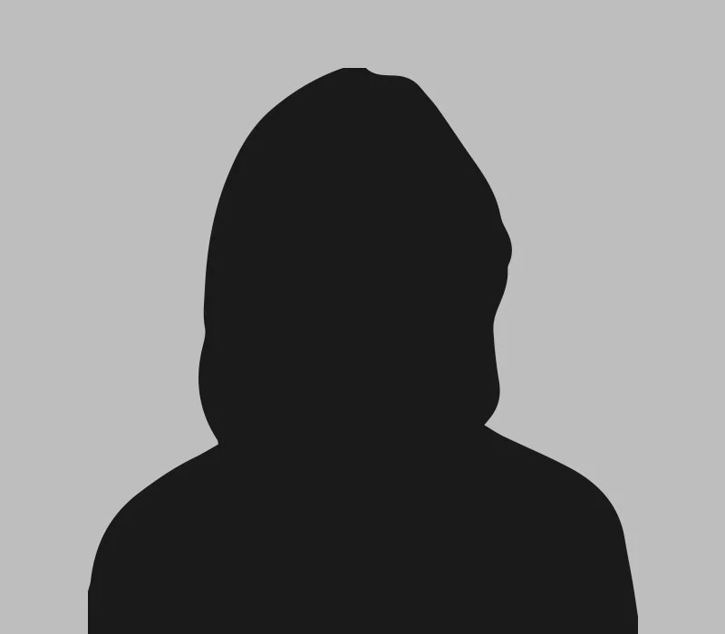 Silhouette of a person with shoulder-length hair against a gray background.