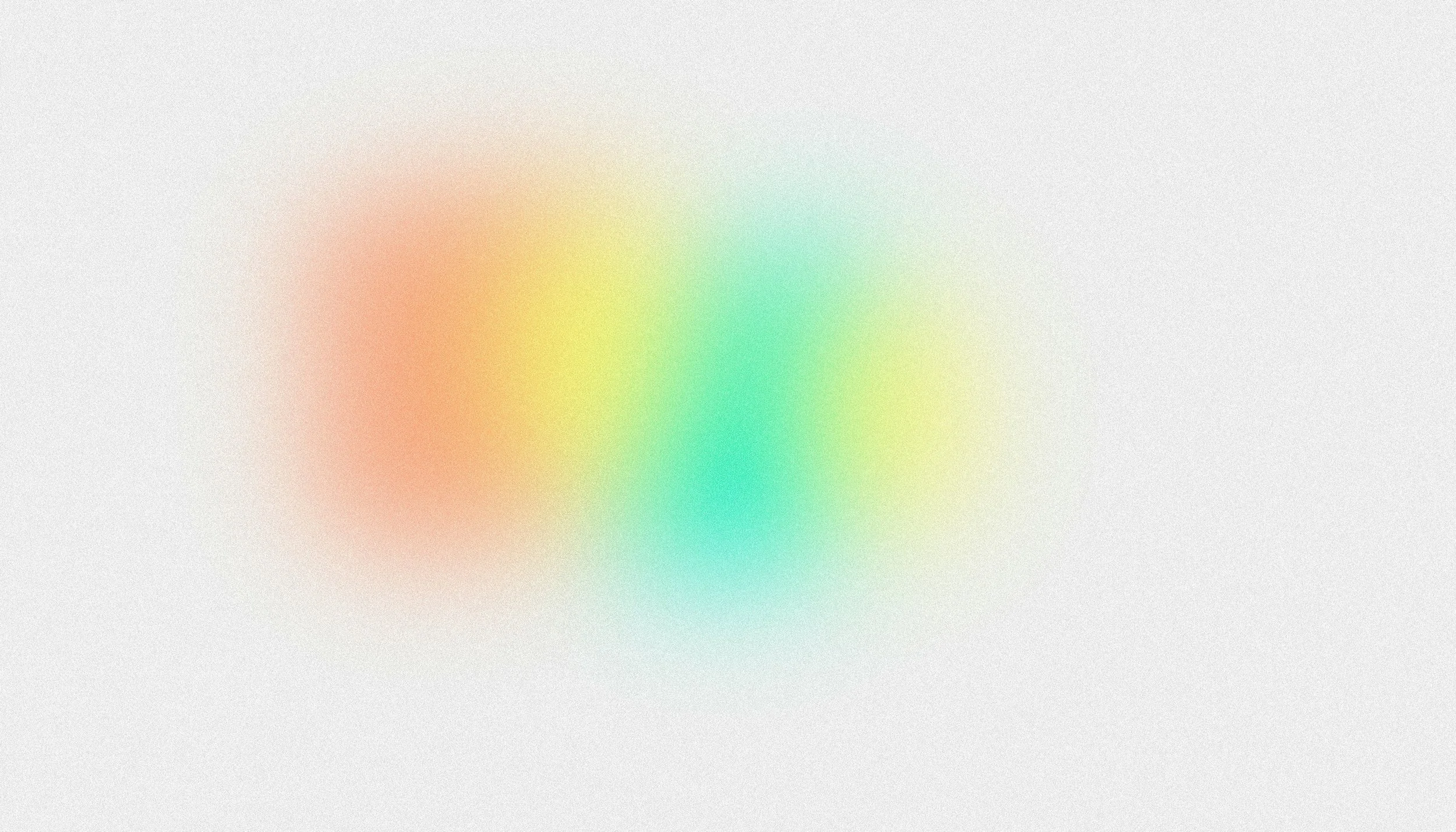 Blurred multicolored abstract background with red, yellow, green, and blue hues.