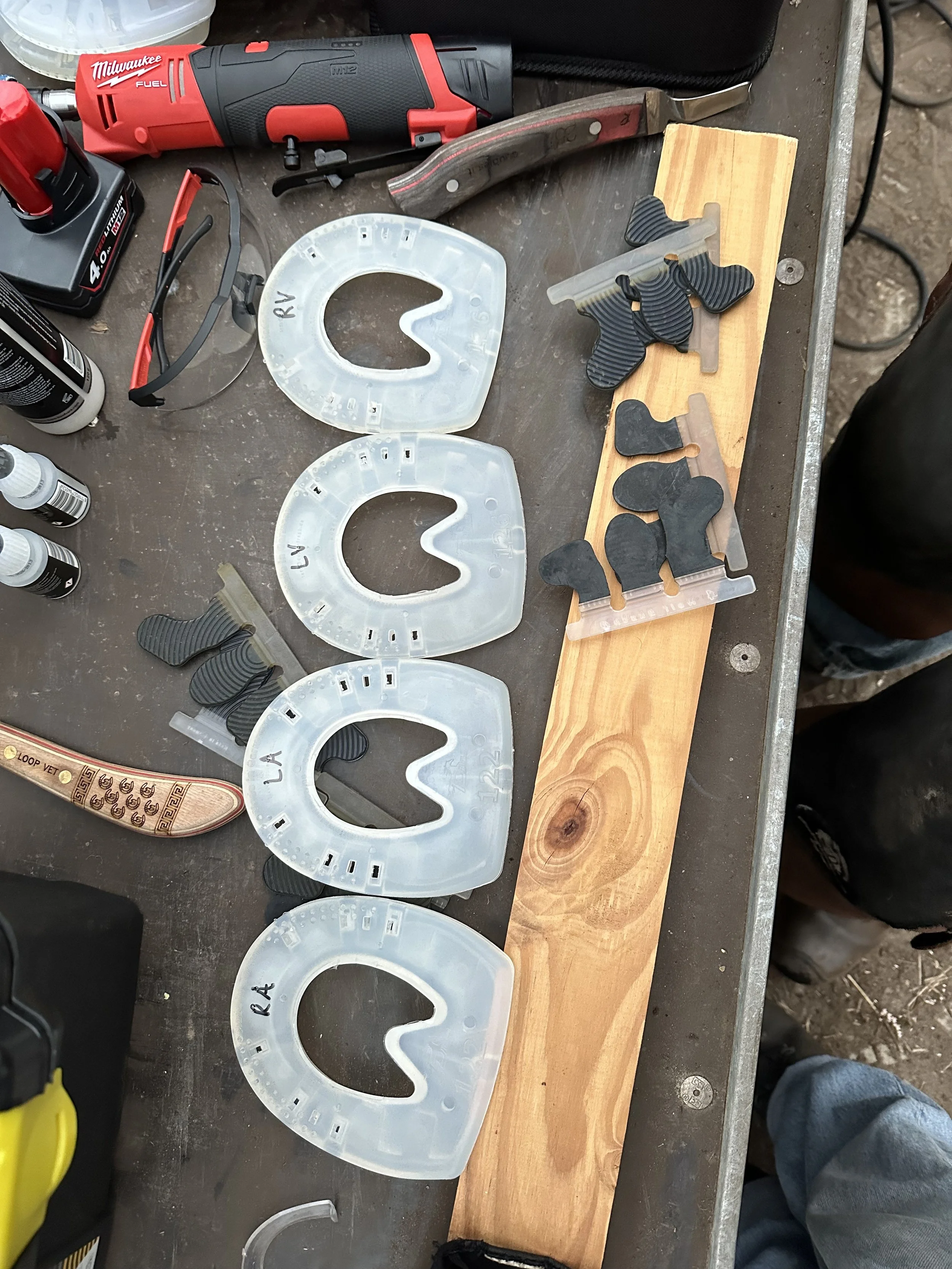 Werkbank met bugenzwembril en meerdere blauwe en zwarte orthopedische zoolstukken.