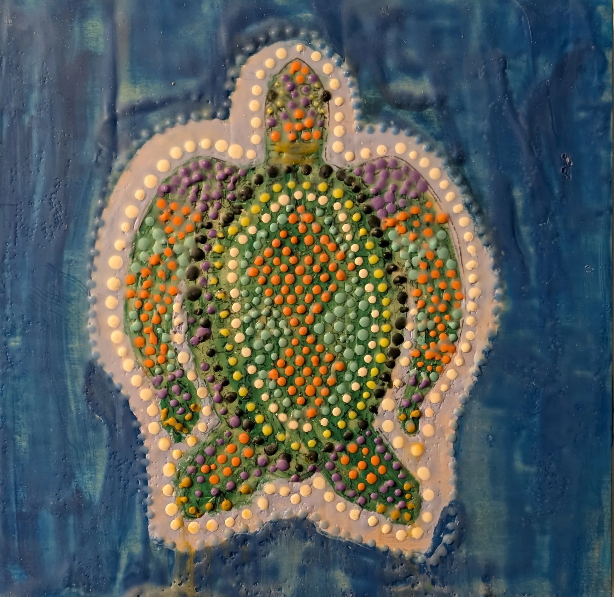 Maori Turtle is a 12x12 encaustic painting on board featuring a radiant sea turtle made with raised dot patterns in vibrant greens, oranges, purples, and yellows. The richly layered wax medium creates a luminous, touchable surface that gives the turt