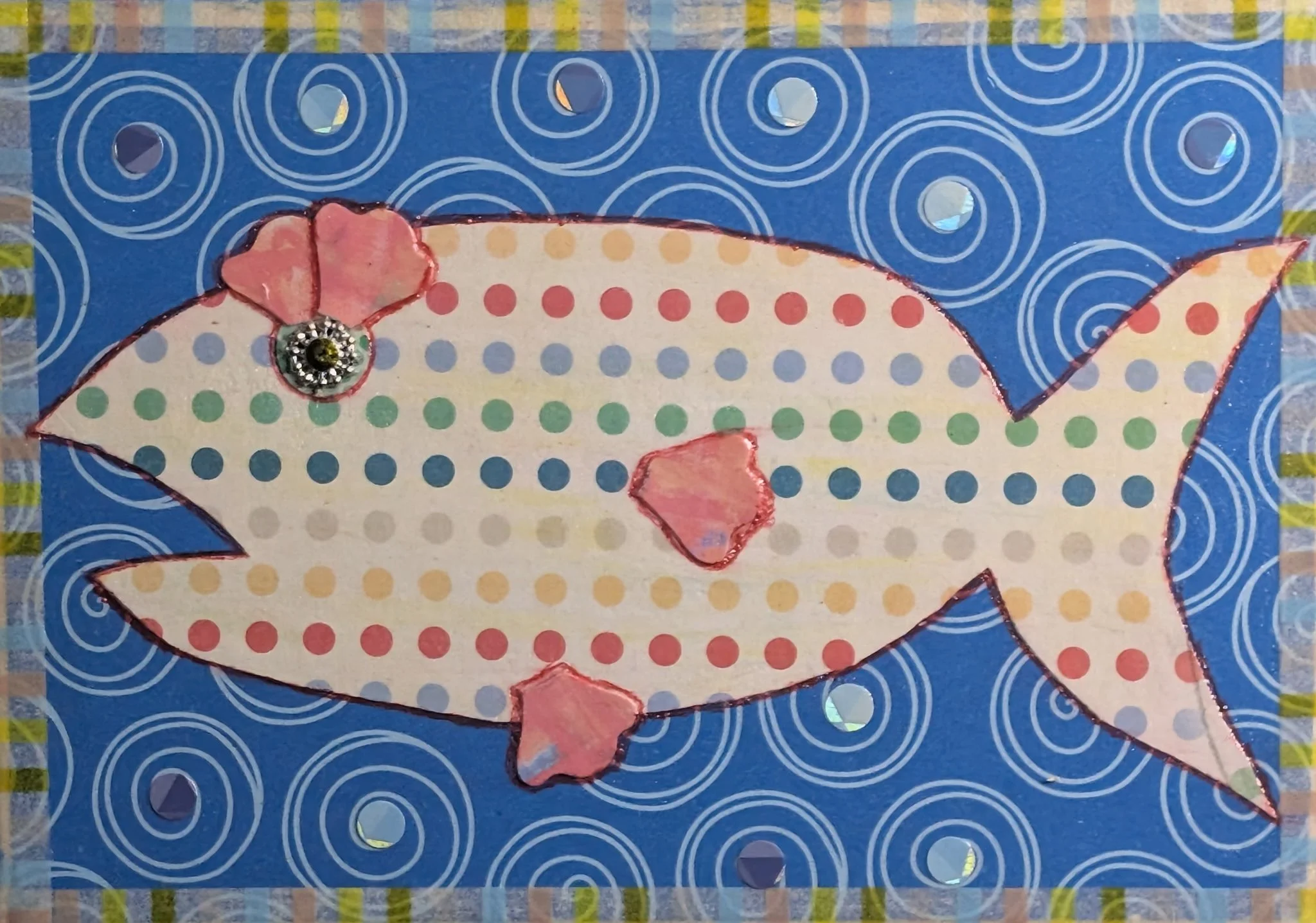 Spotty Dotty is a 5x7 mixed media collage on board featuring a polka dot fish with pink fins, a jeweled eye, and a swirl-filled ocean background. This joyful piece combines bright colors, playful shapes, and hand-cut details for a whimsical underwate