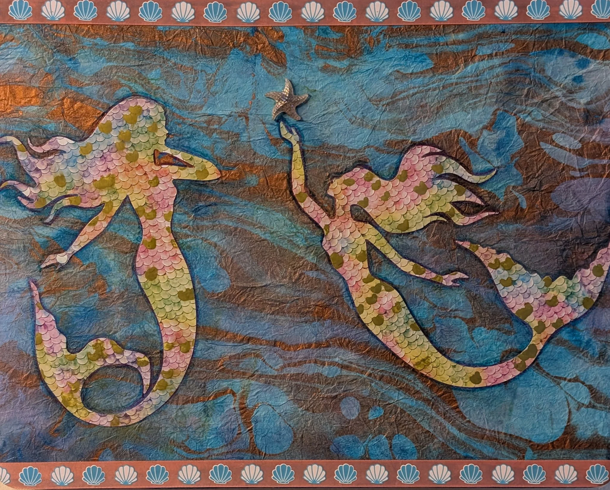 Two mermaids are better than one. Mermaids Frolic is a joyful celebration of underwater wonder, featuring hand-cut scales, textured paper, and a swirling oceanic background. This piece was created on board using layered collage techniques and found t