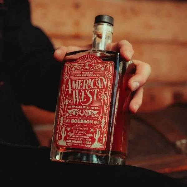 American West Straight Bourbon Whiskey bottle being held