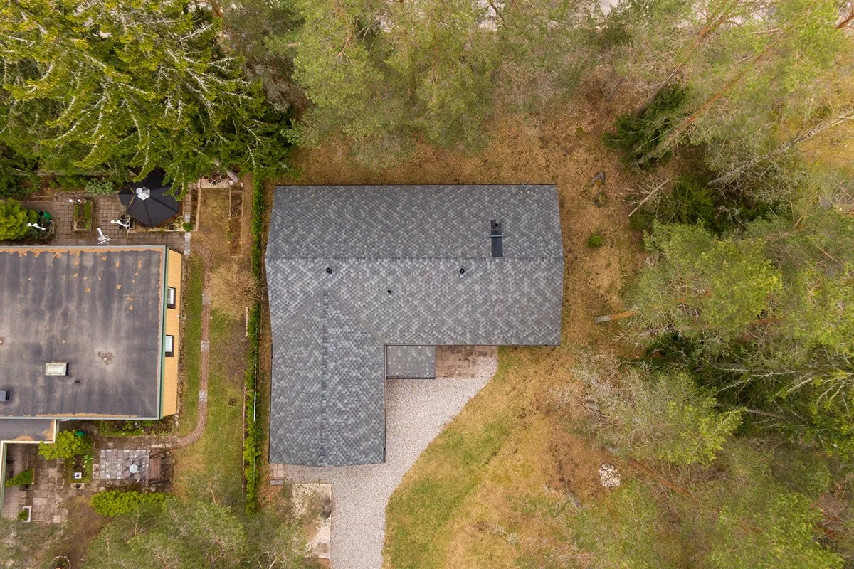 Yläilmo perspektiivistä kuvattu talo ja sen ympärillä kasvavat puut sekä piha-alue.