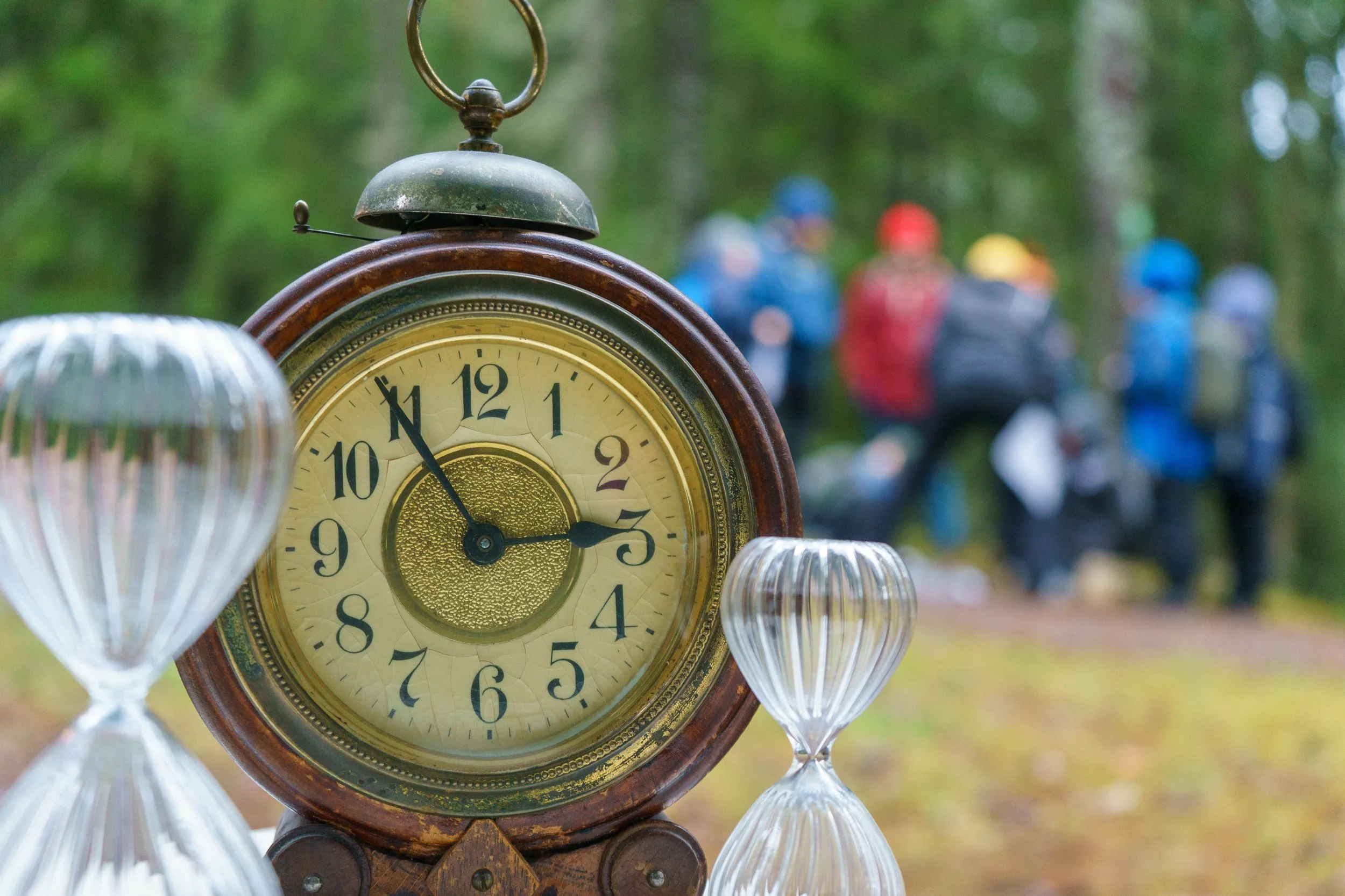 Rauhallinen metsässä oleva ajastin ja kaksi lasipallo-figuuria