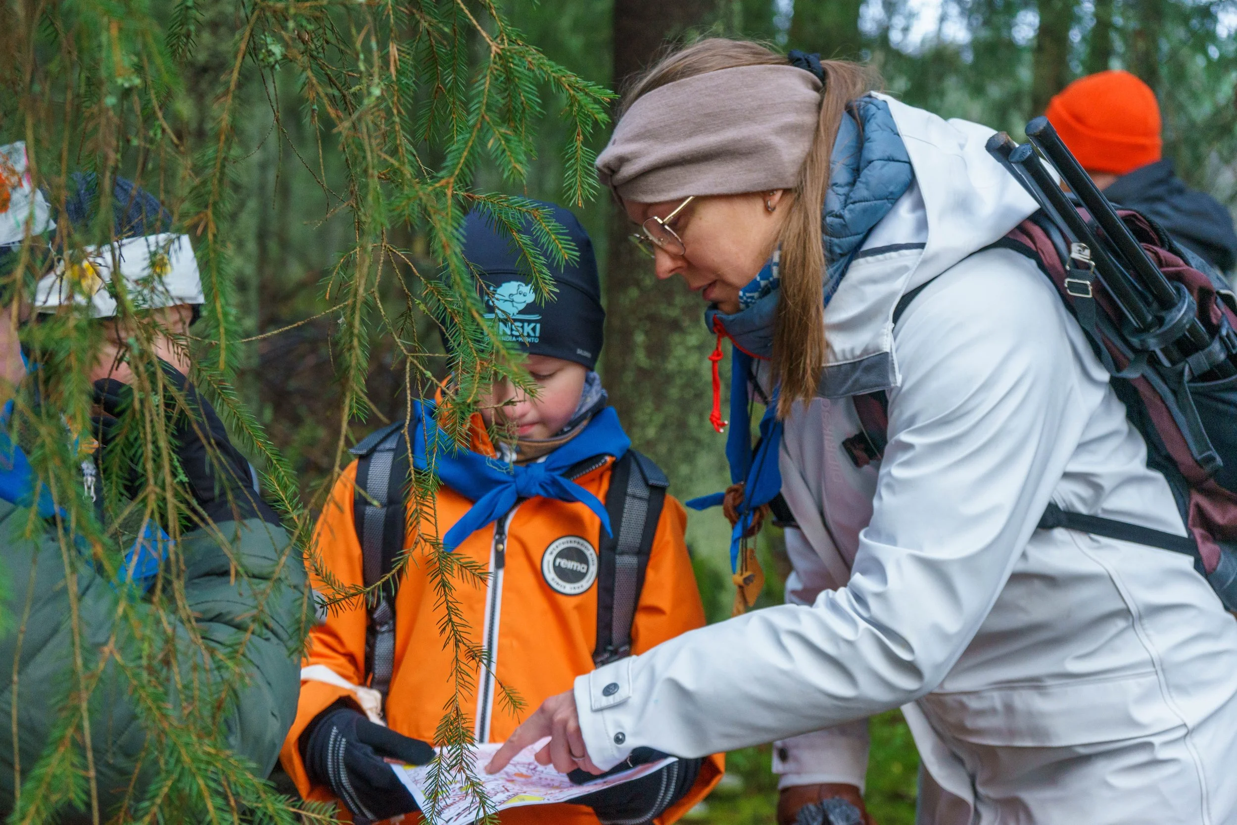 Perhe, joka on retkellä metsässä tutkien karttaa
