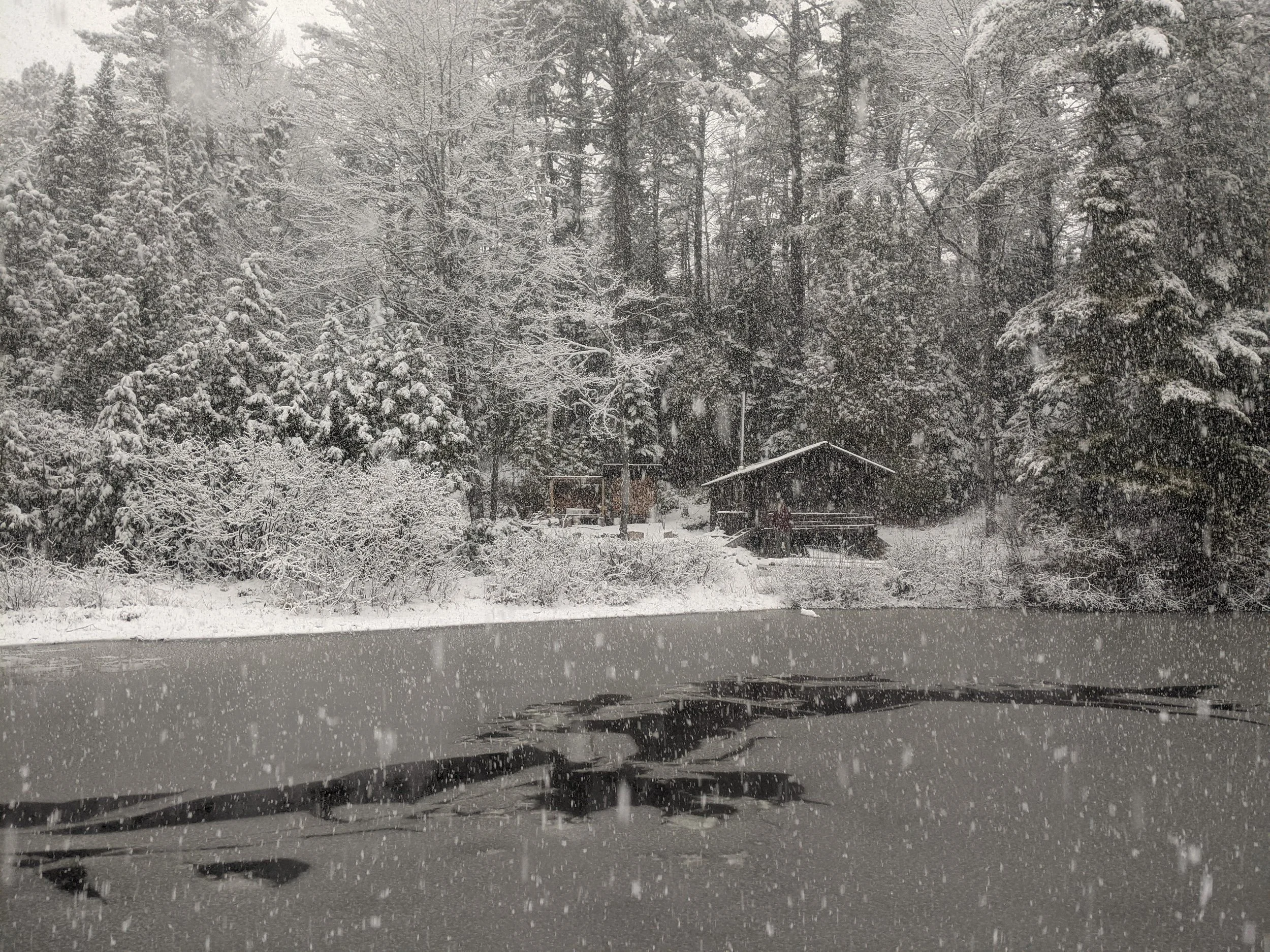 Paddleboarding through a freezing lake. Winter is the most peaceful time at camp. Woodstove keeps it warm inside.