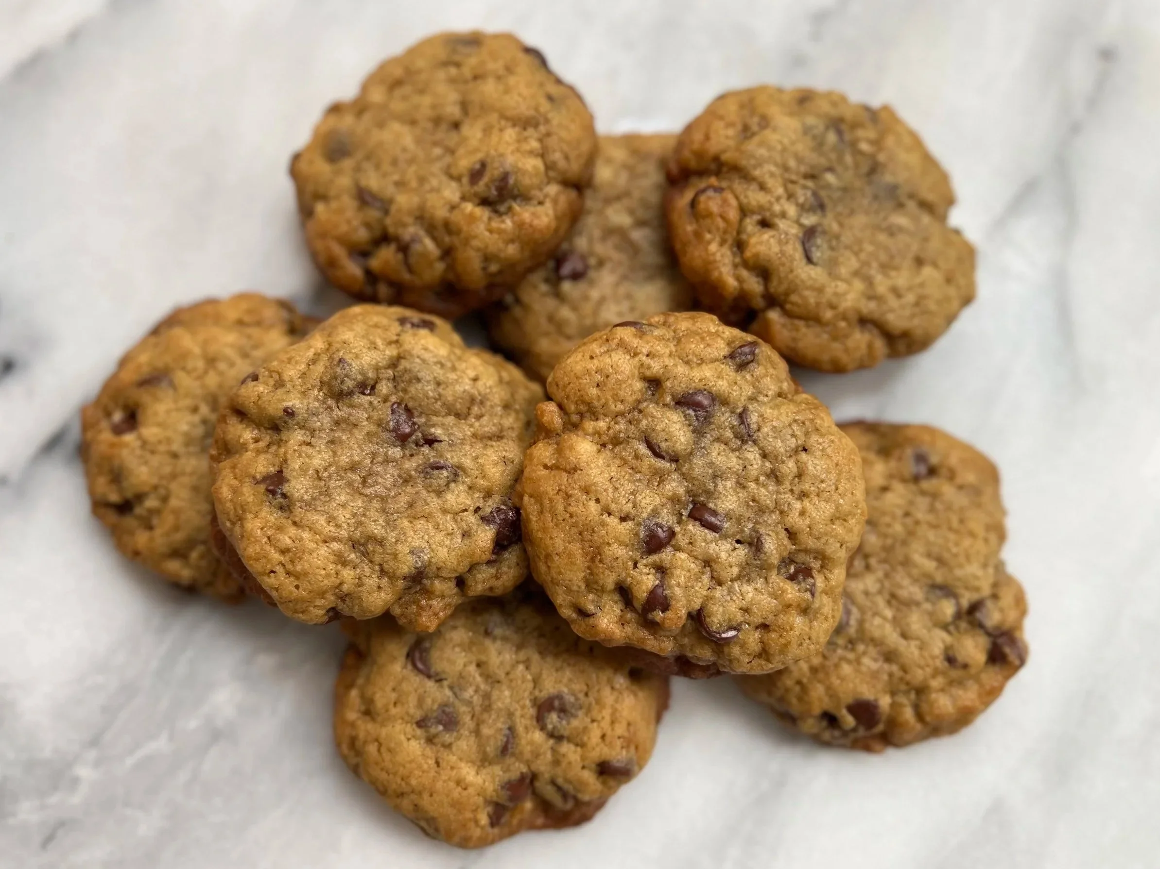 Group of chocolate chip cookies on parchment paper.