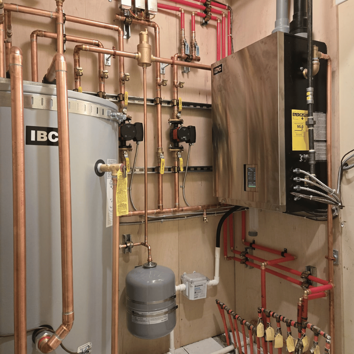 Boiler, water heater, and circulating pump installed by Bluestone Plumbing in a Vancouver mechanical room.