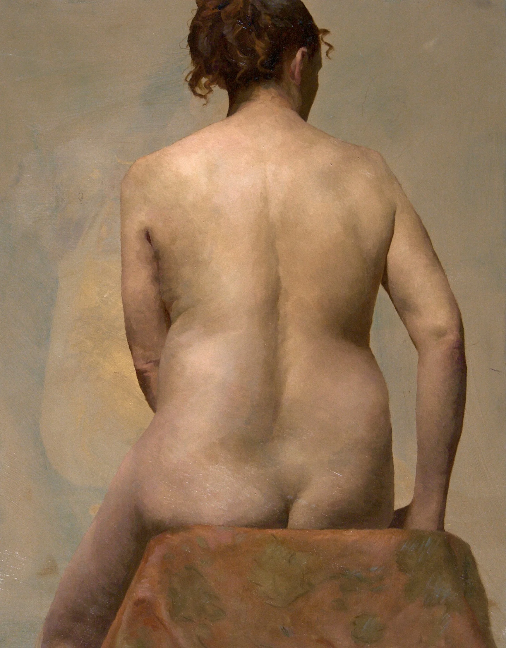 Nude woman with red hair seen from the back, sitting on a surface, with a neutral background.