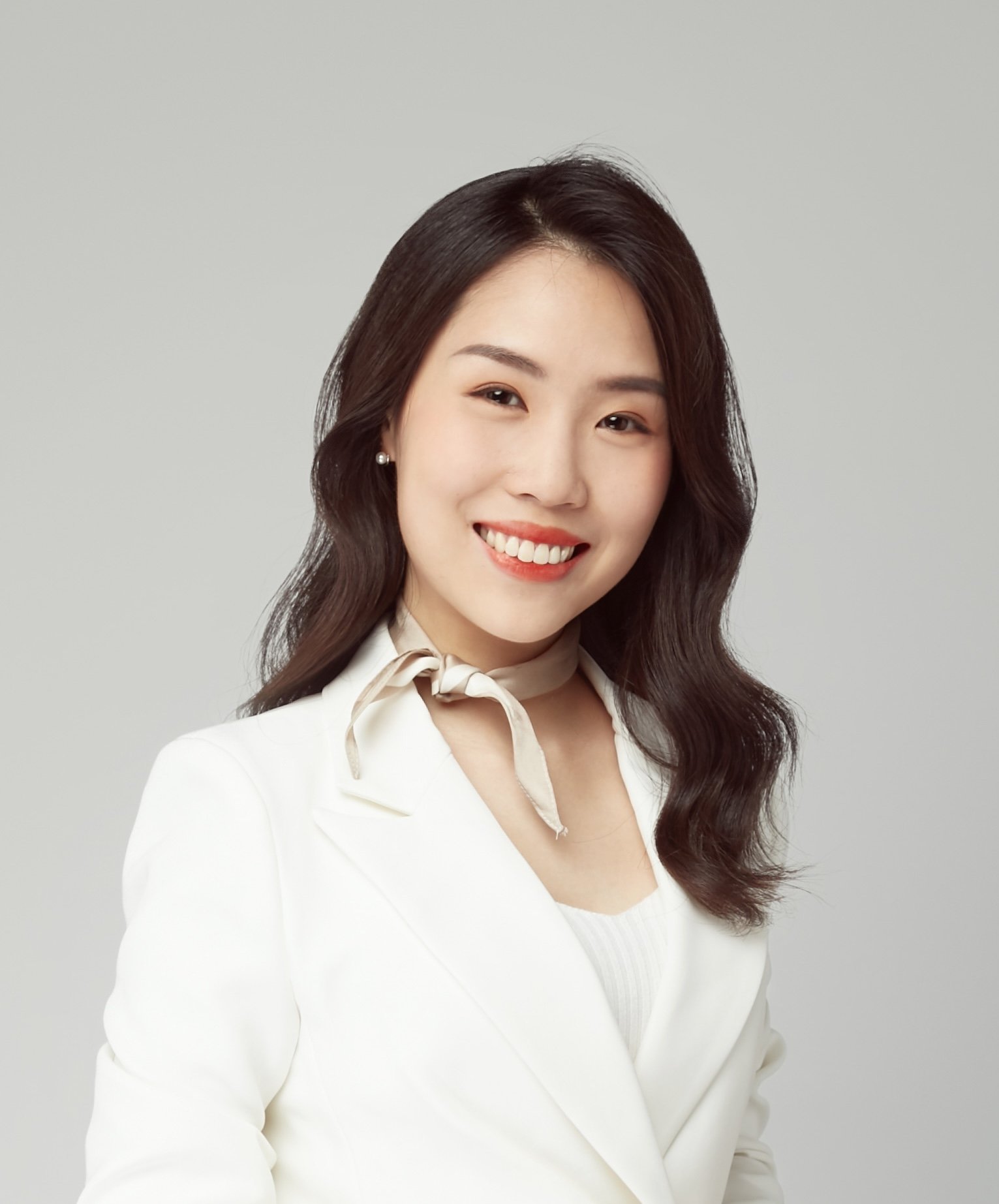 Shujie Yin, Legal Assistant wearing a neck scarf atop a cream, off-white coloured blazer