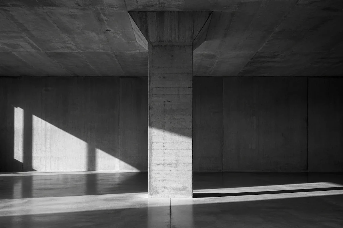 Single concrete column carrying a heavy ceiling slab — the founder as the only working part of the structure