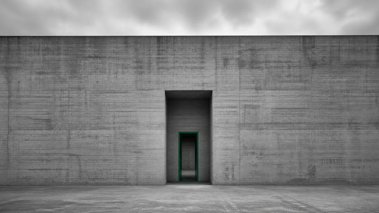 Brutalist concrete wall with single narrow doorway — why founders can't step back from their business