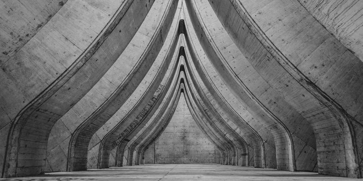 Underground concrete tunnel with arched supports.