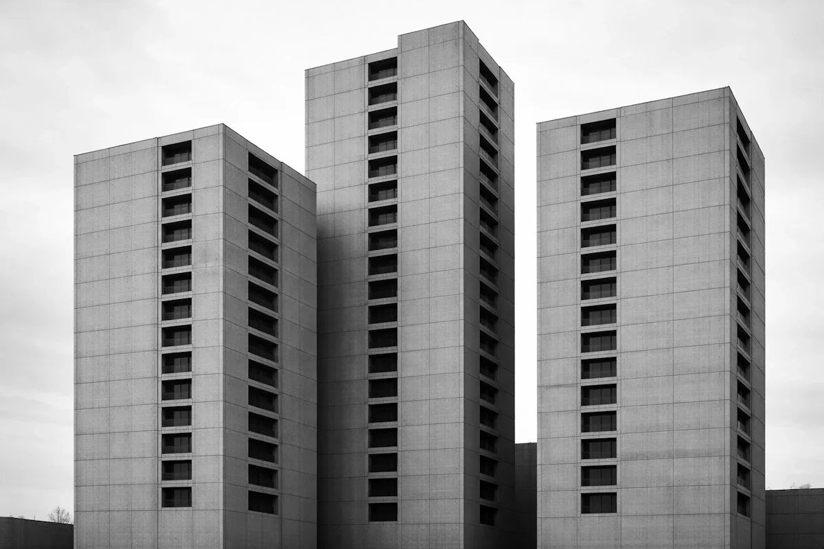 Three brutalist concrete towers separated by narrow gaps with no connecting walkways — fragmented operations and disconnected systems in a growing business.