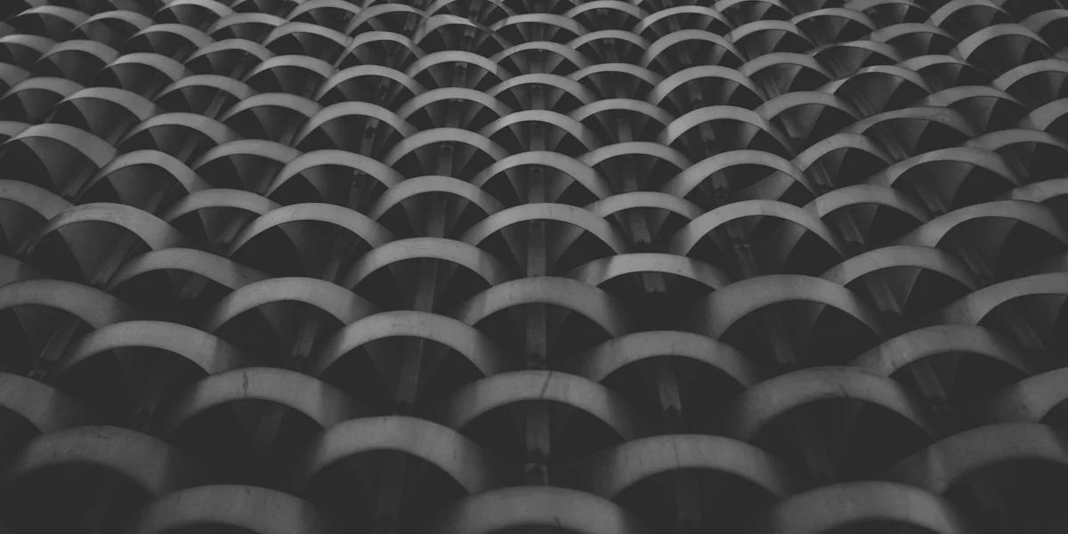 Repeating curved concrete forms in shadow — get in touch with GrowthPains