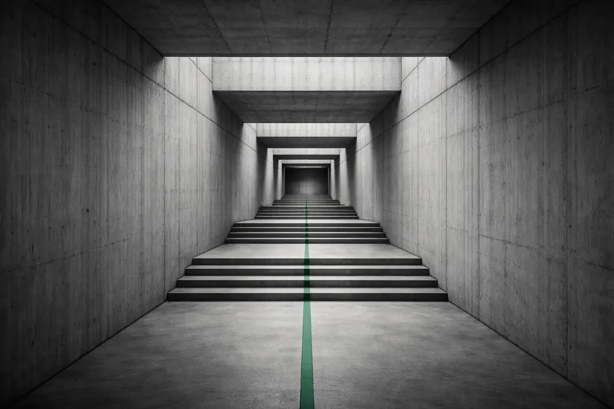 Concrete corridor descending in steps with a single green line on the floor — the method for working out where to fix first