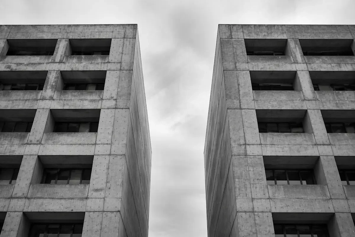 Two brutalist tower blocks separated by a gap with no connecting bridge — where the lead-to-cash workflow breaks between stages