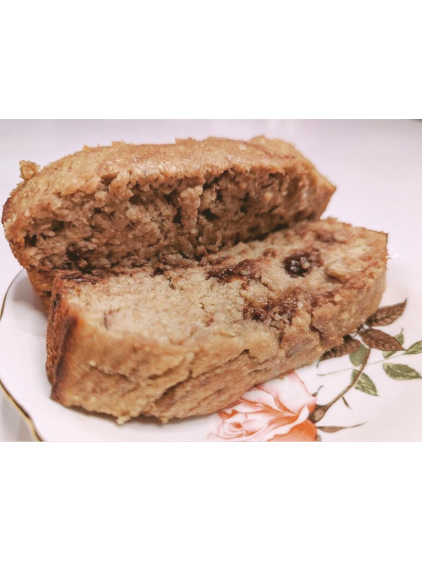 Close-up of a slice of banana bread with chocolate chips on a floral plate.