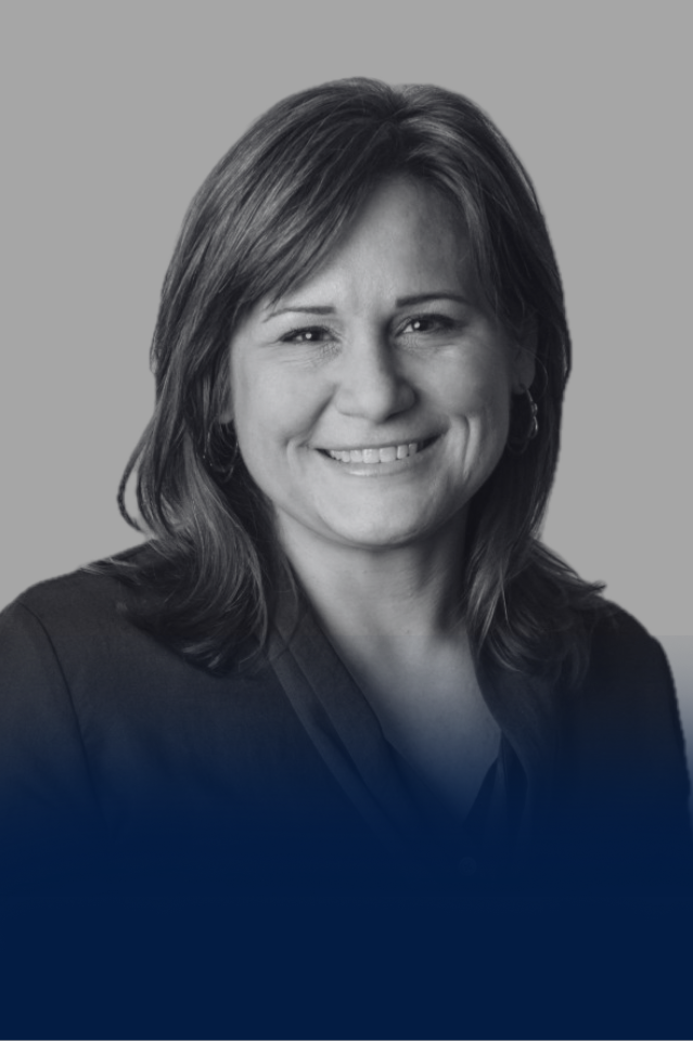 Black and white portrait of a woman with shoulder-length hair, smiling, wearing earrings and a dark top.