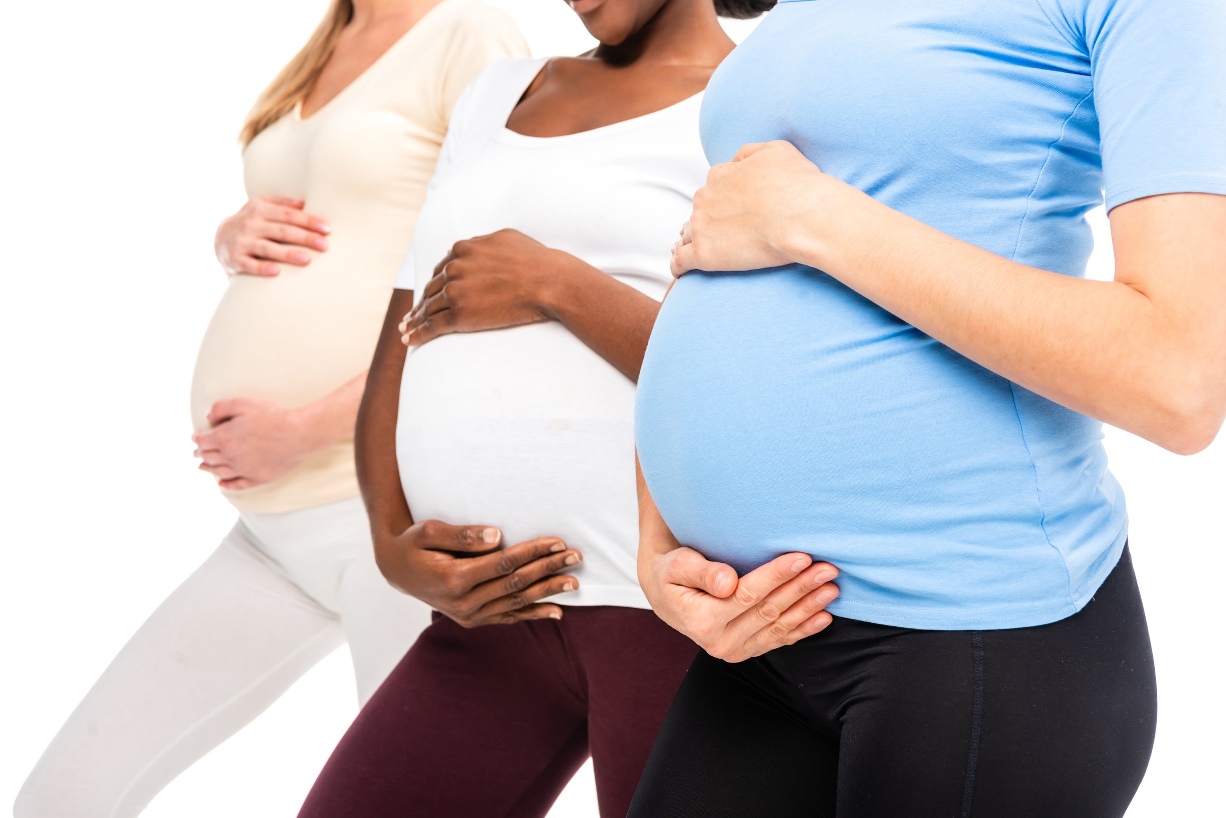 Three pregnant women standing side by side, each with one hand on their baby bump.