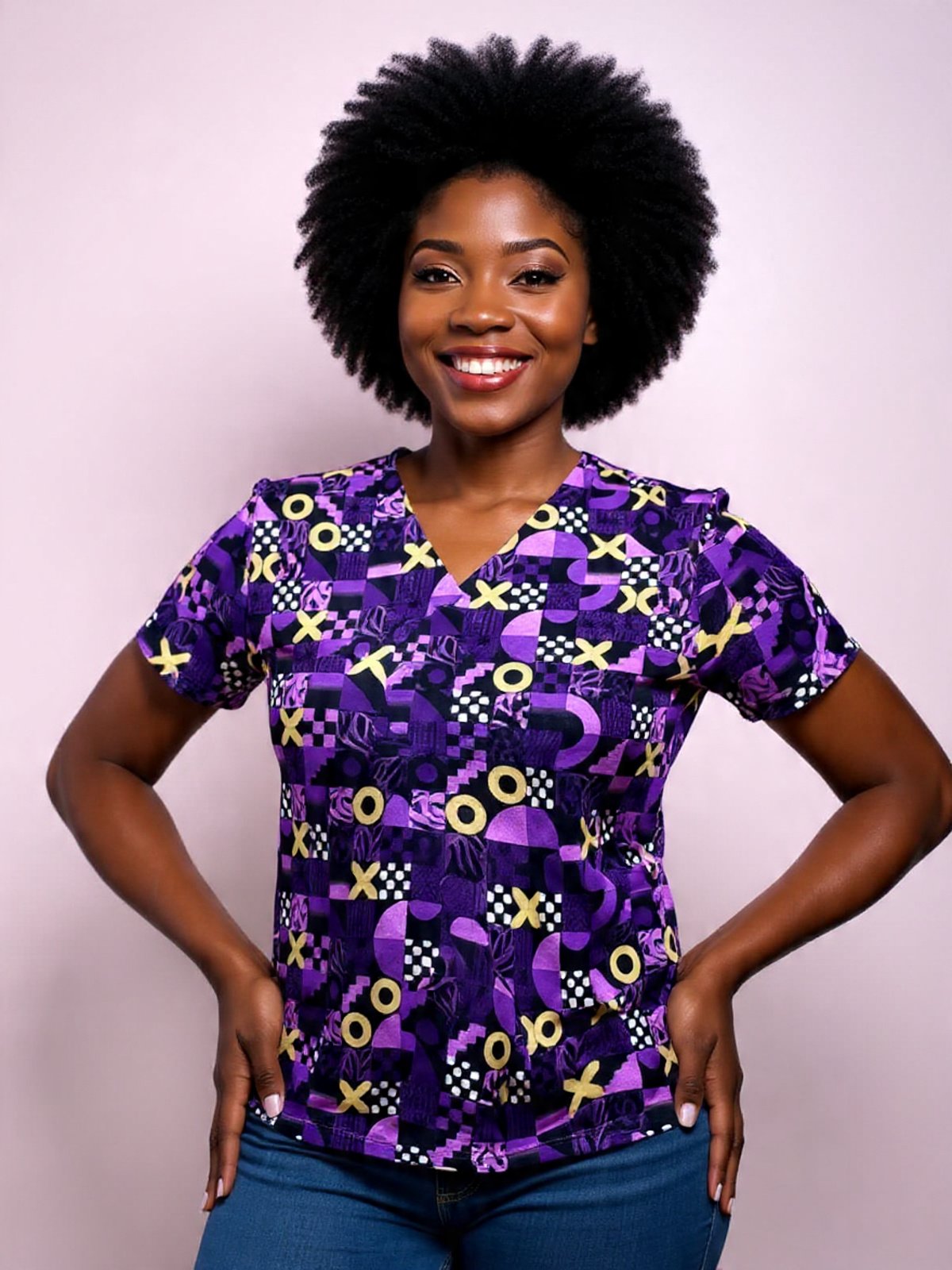 A woman with dark skin and a big Afro hairstyle standing confidently with a smile. She is wearing a vibrant purple patterned shirt and blue jeans, standing against a light pink background.