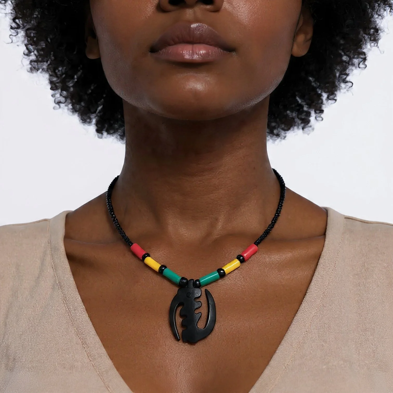 A woman wears a colorful beaded necklace with a black abstract pendant.