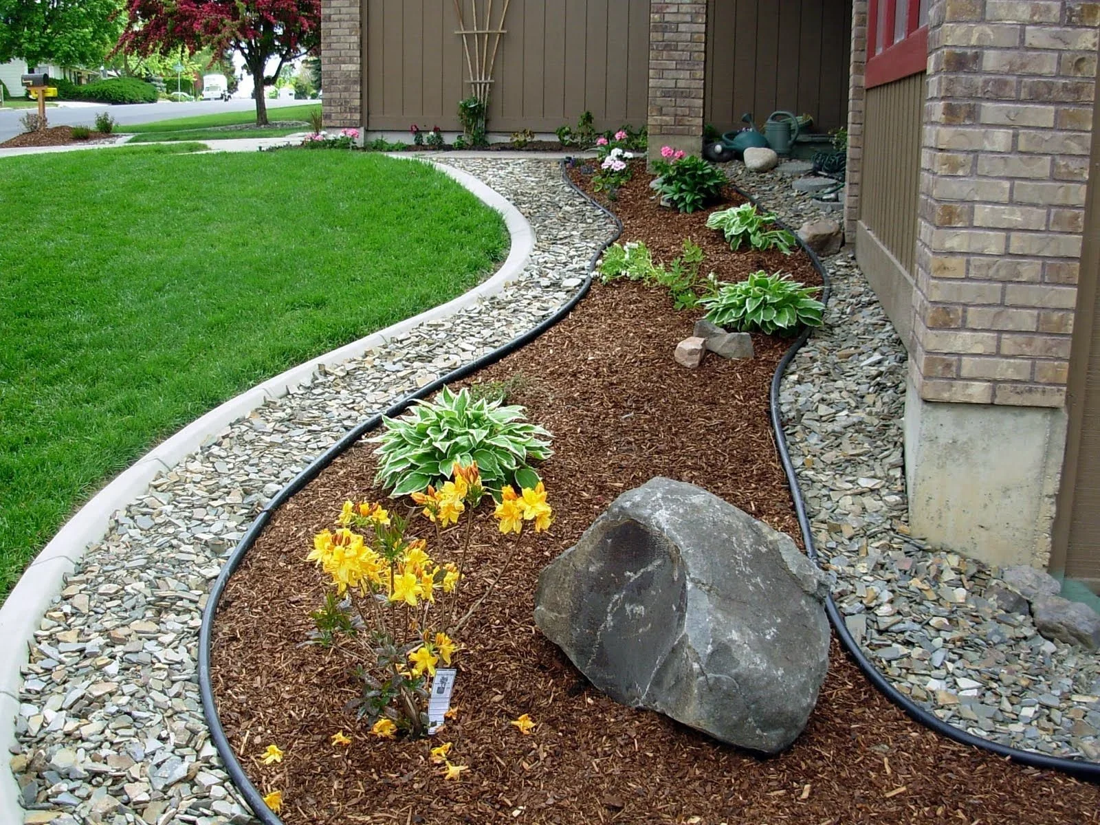 Mulch and decorative rock installation with flower bed edging by BendScape Lawn Care in Bend Oregon