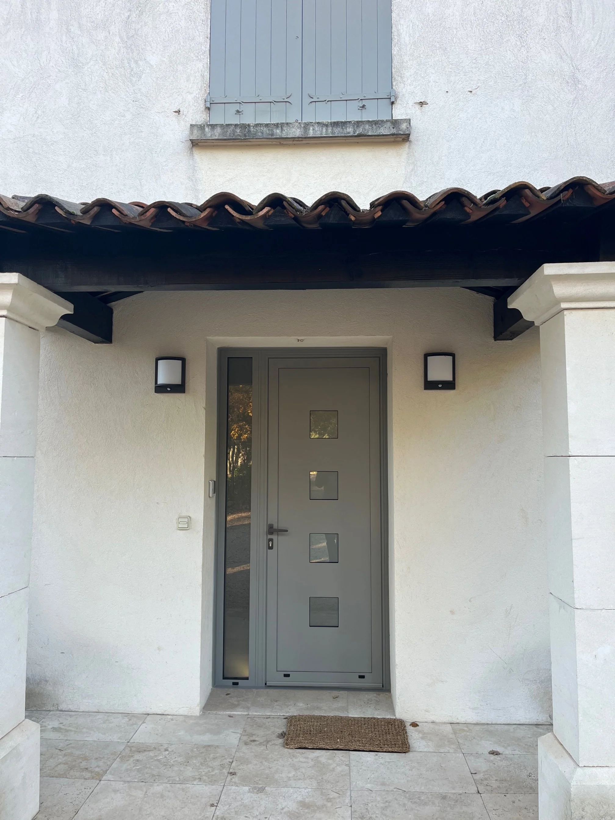 Porte d'entrée d'une maison, villa, grise avec des carreaux vitrés