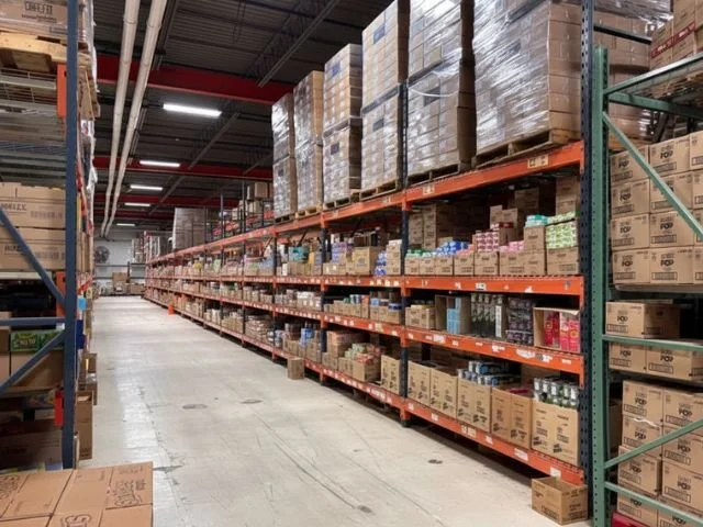 Warehouse aisle with shelves stocked with boxes and pallets