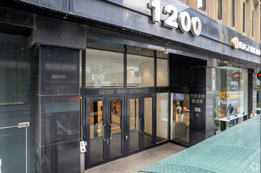 Entrance of a building at 1200 Bay Street with glass doors and windows, black exterior.